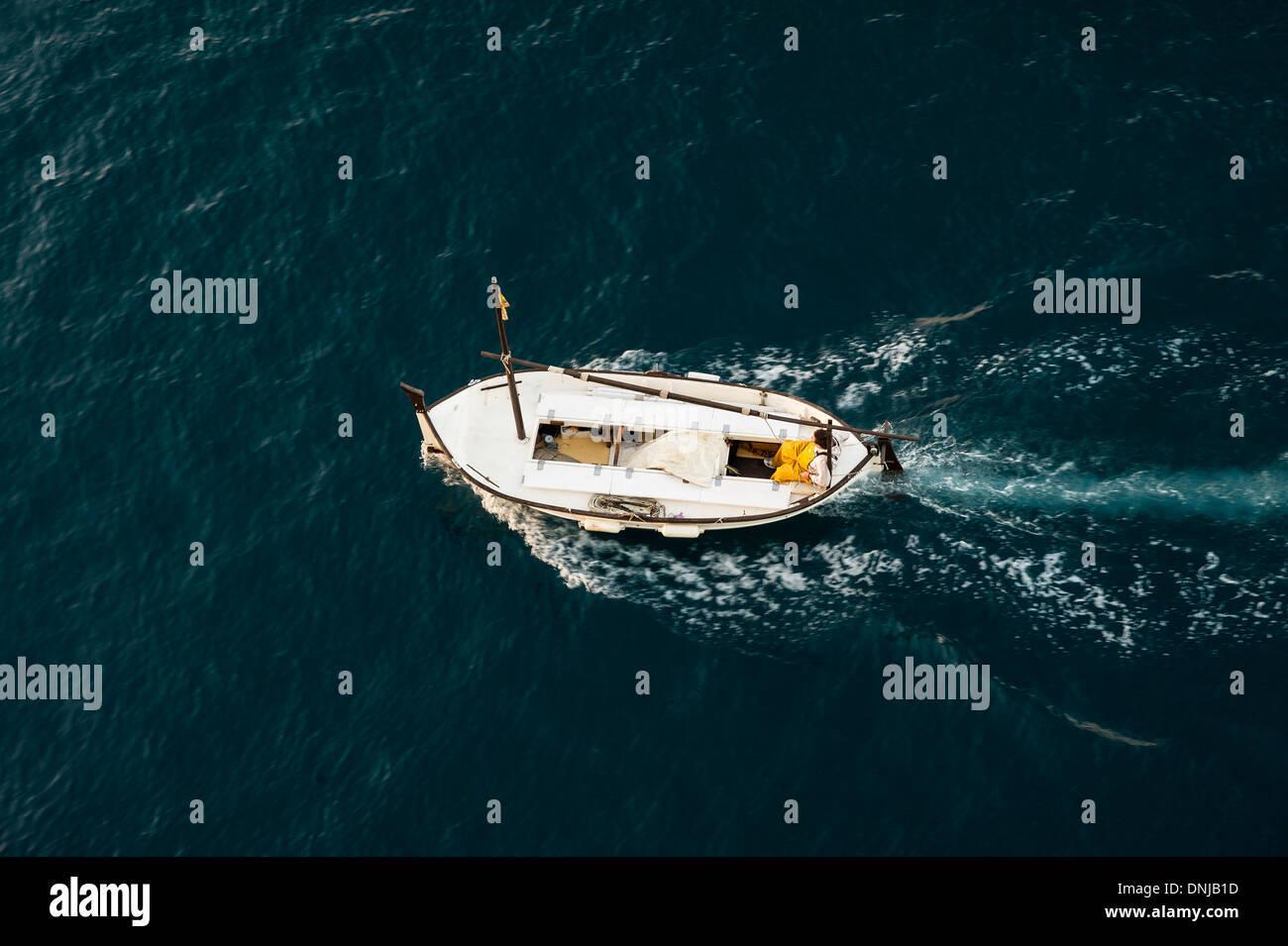 Pescatore su una piccola barca da pesca in mare. Foto Stock