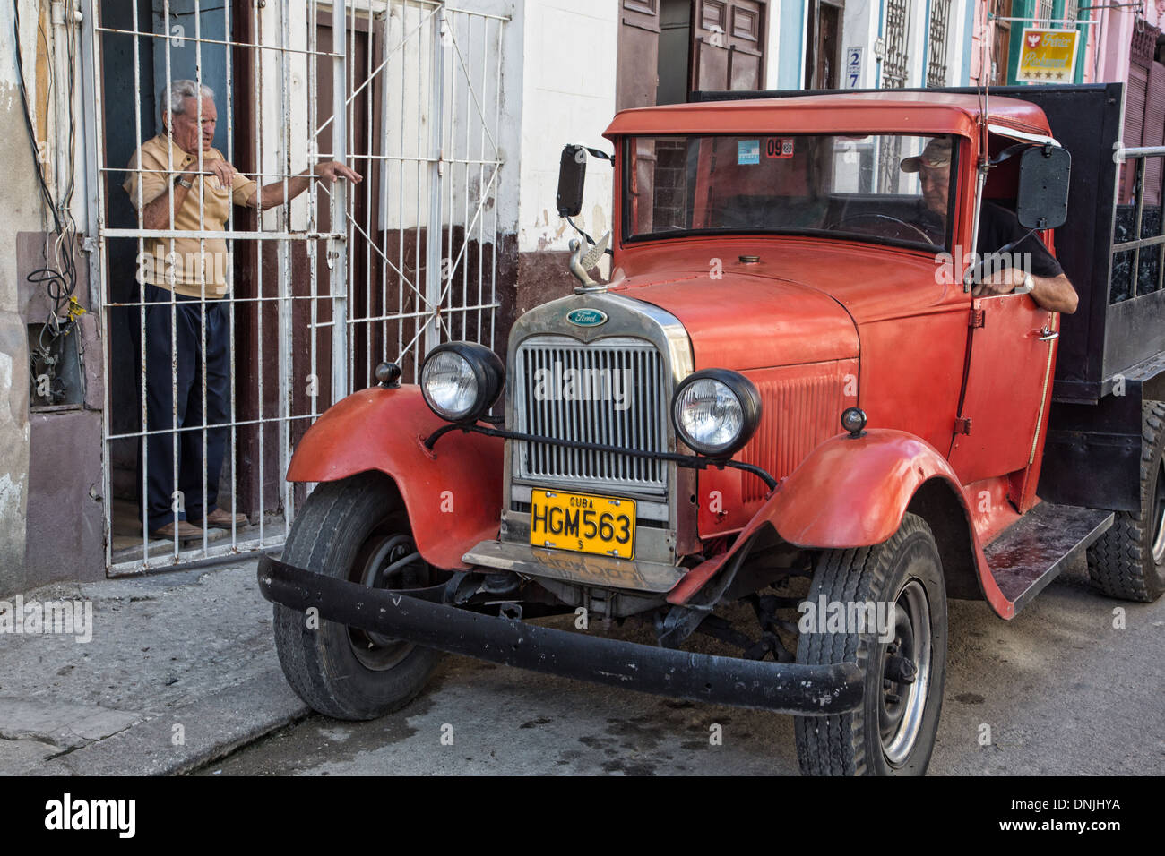 DELIVERYMAN in una vecchia vettura americana, Havana, Cuba, CARAIBI Foto Stock