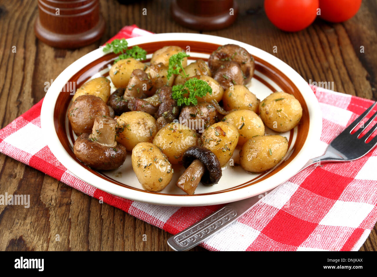 Rosolare gli champignon con rosmarino patata e forcella, close up Foto Stock
