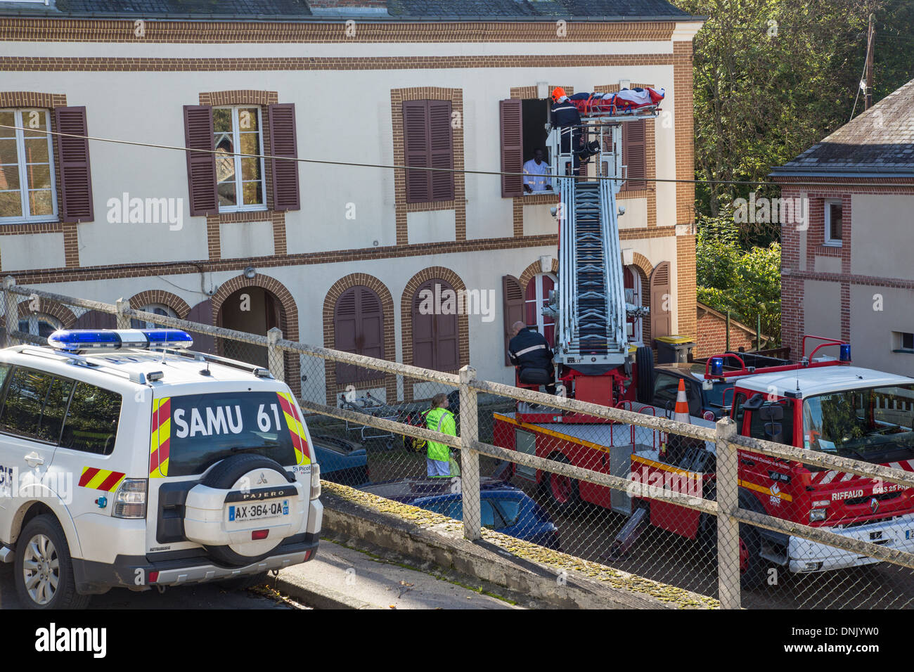 Evacuare una vittima con il dipartimento dei vigili del fuoco della scala mentre SAMU (servizio di emergenza) medici attendere, RUGLES, Eure (27), Francia Foto Stock