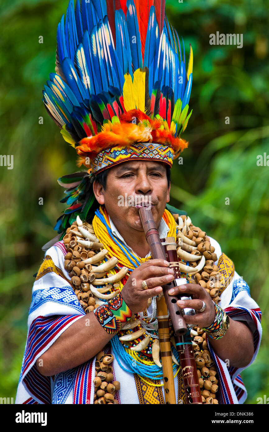 Uno sciamano dalla tribù kamentsá, indossando un colorato copricapo di  piume, suona il flauto durante il carnevale a sibundoy, Colombia Foto stock  - Alamy