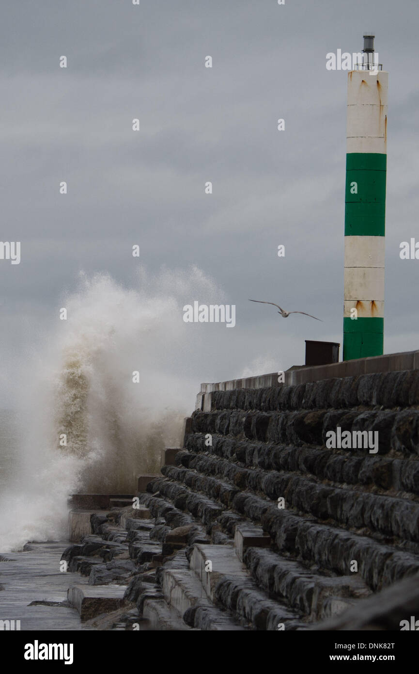 Aberystwyth, Wales, Regno Unito. Il 1 gennaio 2014. Il giorno di nuovi anni 2014 onde pastella la parete del porto a Aberystwyth su Cardigan Bay costa, West Wales. Ancora un altro sistema di tempesta spazia dall'Atlantico per portare alta venti, onde grandi e guida sotto la pioggia per la costa occidentale del Regno Unito. Photo credit: keith morris/Alamy Live News Foto Stock