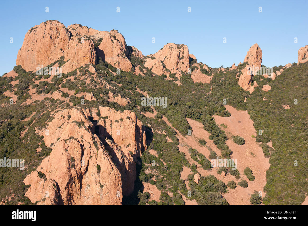 VISTA AEREA. Buttes e pinnacoli in una roccia rossa di origine vulcanica. Saint-Raphaël, Estérel Massif, Var, Costa Azzurra, Francia. Foto Stock