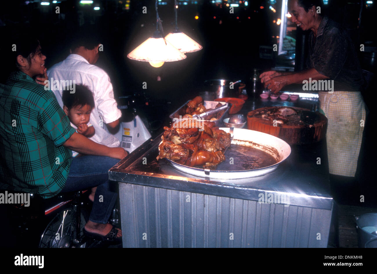 Condizioni di mercato non igieniche con la famiglia su scooter acquistare cibo a Bangkok, Thailandia Foto Stock