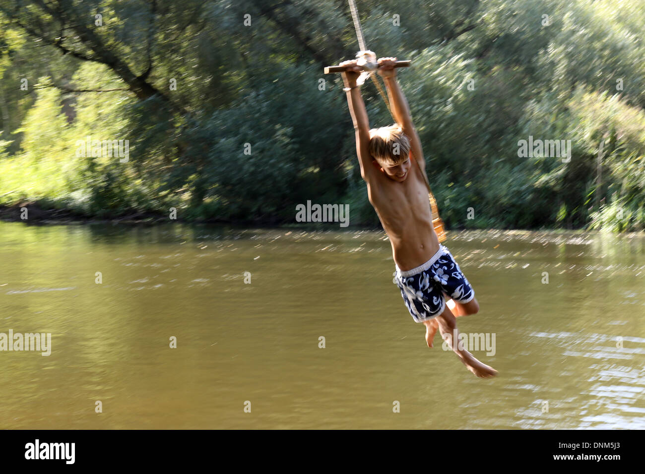 Briescht, Germania, ragazzo basculante in una corda sopra le acque del fiume Sprea Foto Stock