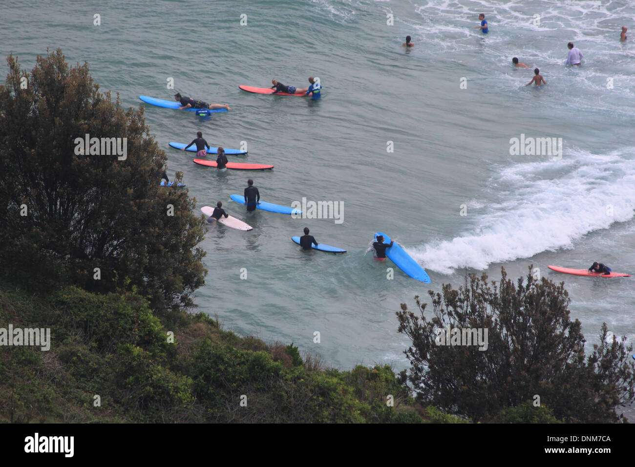 Una fotografia di un gruppi di surfisti di imparare a navigare in spiaggia in Australia. Foto Stock