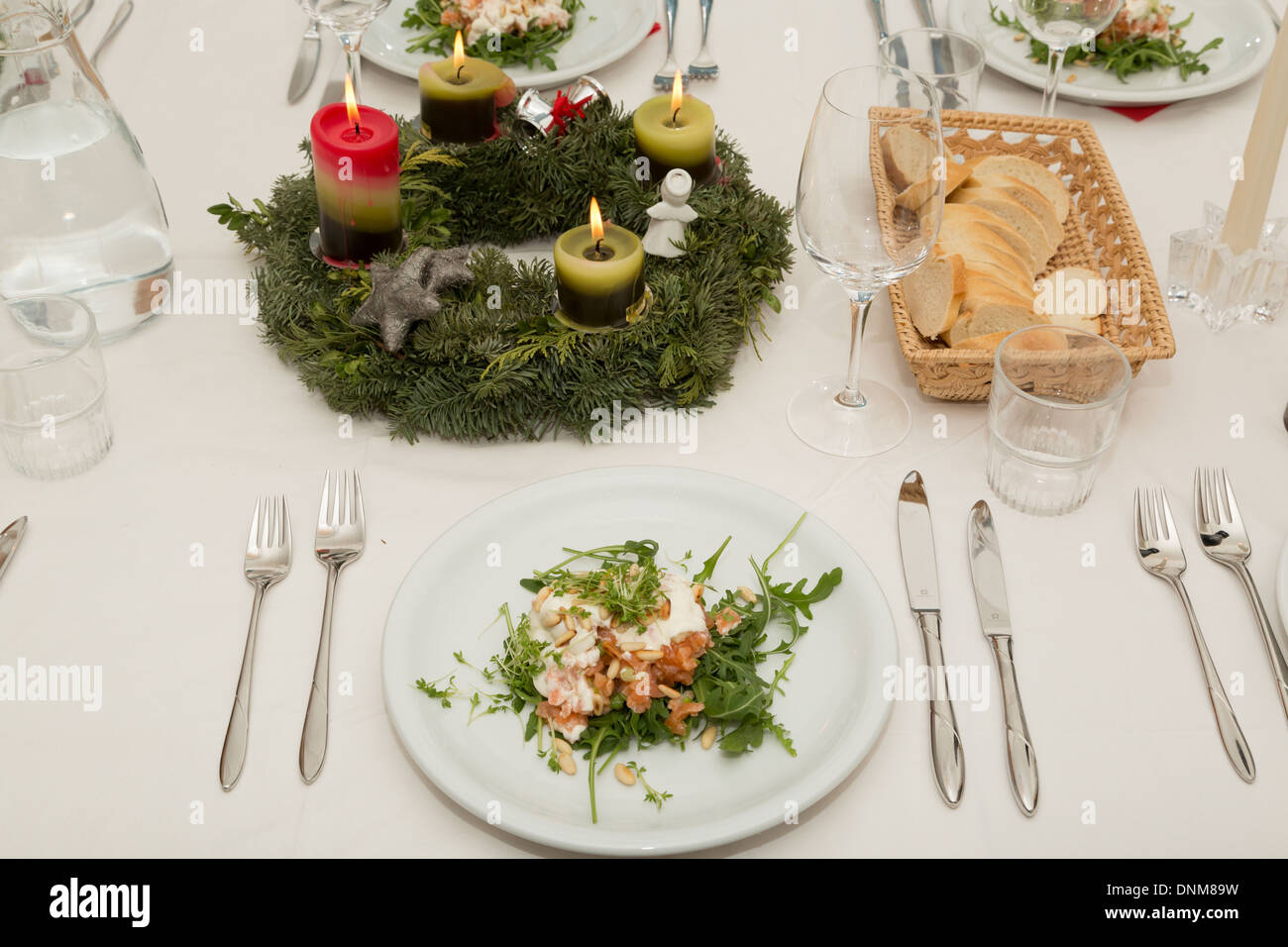 Una fotografia di una messa in tavola al tempo di Natale. Antipasto di Tartara di salmone, crema e Tostate i pinoli è stato servito. Foto Stock