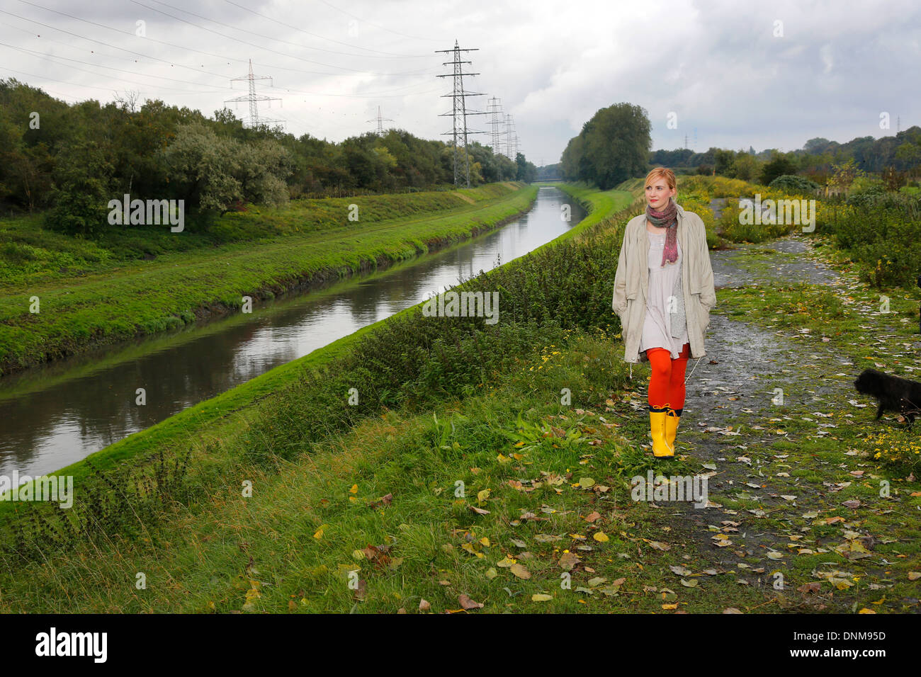 Oberhausen, Germania, una giovane donna va per una passeggiata sotto la pioggia a Emscher Foto Stock