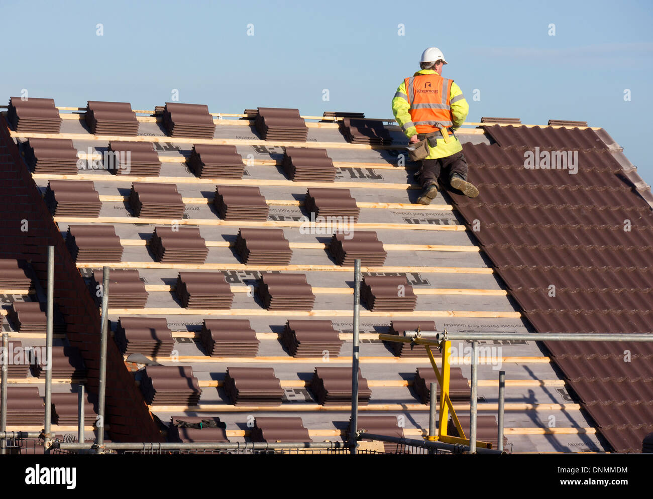 L'uomo la posa di tegole del tetto sulle nuove case residenziali, Grantham, Lincolnshire Foto Stock