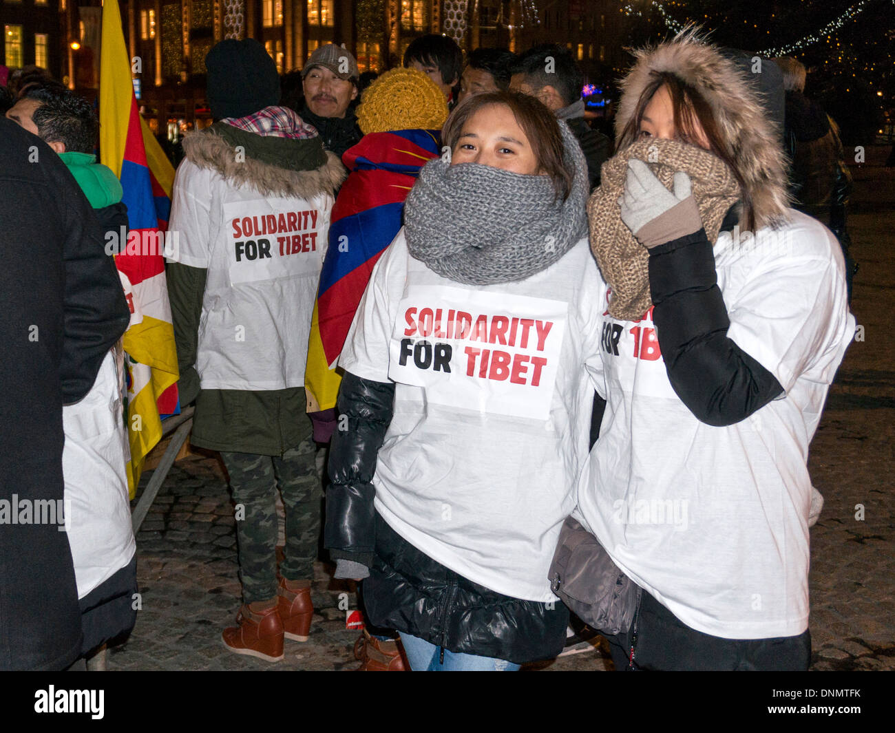 Due giovani manifestanti femmina nascondere le loro facce mentre invoca la solidarietà per il Tibet in piazza Dam, Amsterdam. Foto Stock