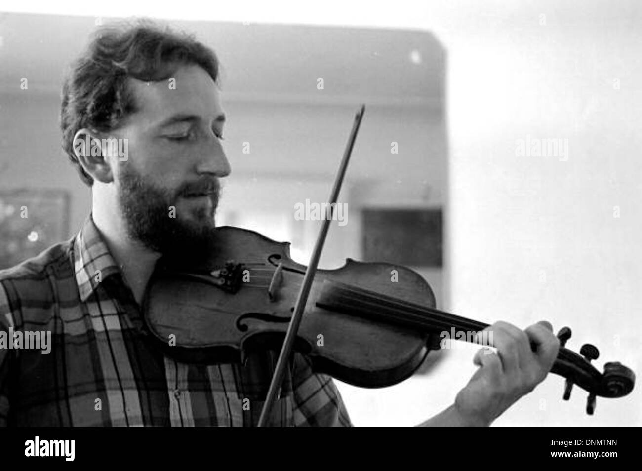 James Kelly viene mostrato mentre suona il violino irlandese a Miami, in Florida, durante gli anni '1980 L'immagine lo cattura eseguendo musica folk irlandese, con particolare attenzione alla sua tecnica e al violino come strumento ad arco. Foto Stock