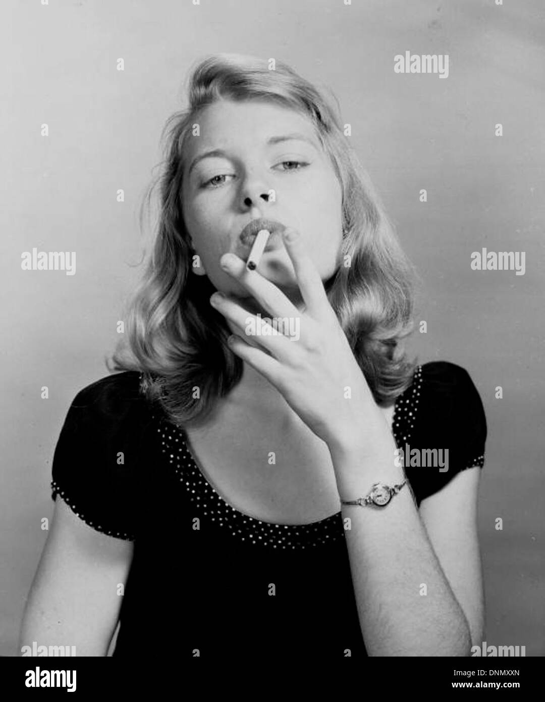 Una fotografia degli anni '1940 di una ragazza che promuove le sigarette Lucky Strike, con un modello biondo in una pubblicità. L'immagine fa parte della collezione Joseph Janney Steinmetz e riflette le tendenze pubblicitarie dell'industria del tabacco durante quell'epoca. Foto Stock