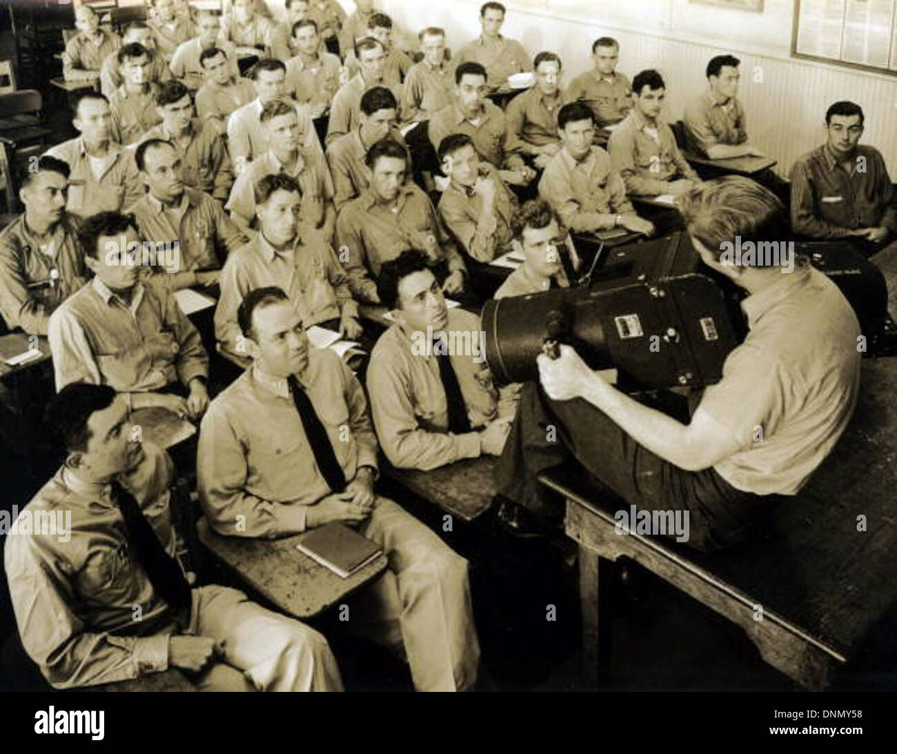 Un'immagine degli anni '1940 della Joseph Janney Steinmetz Collection che mostra un istruttore e gli studenti della Naval Photography School di NAS Pensacola, situata nella contea di Escambia, in Florida. La fotografia cattura i fotografi della Marina durante l'addestramento, circondati da attrezzature fotografiche aeree in un'aula, che riflettono i preparativi della Marina degli Stati Uniti durante la seconda guerra mondiale. Foto Stock