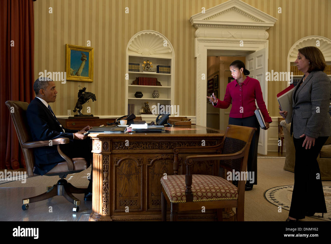 Il Presidente Usa Barack Obama parla con i consulenti Susan Rice e Lisa Monaco prima della sua telefonata con il Cancelliere Angela Merkel della Germania per discutere le più recenti perdite NSA da Edward Snowden all Ufficio Ovale della Casa Bianca Ottobre 23, 2013 a Washington, DC. Foto Stock