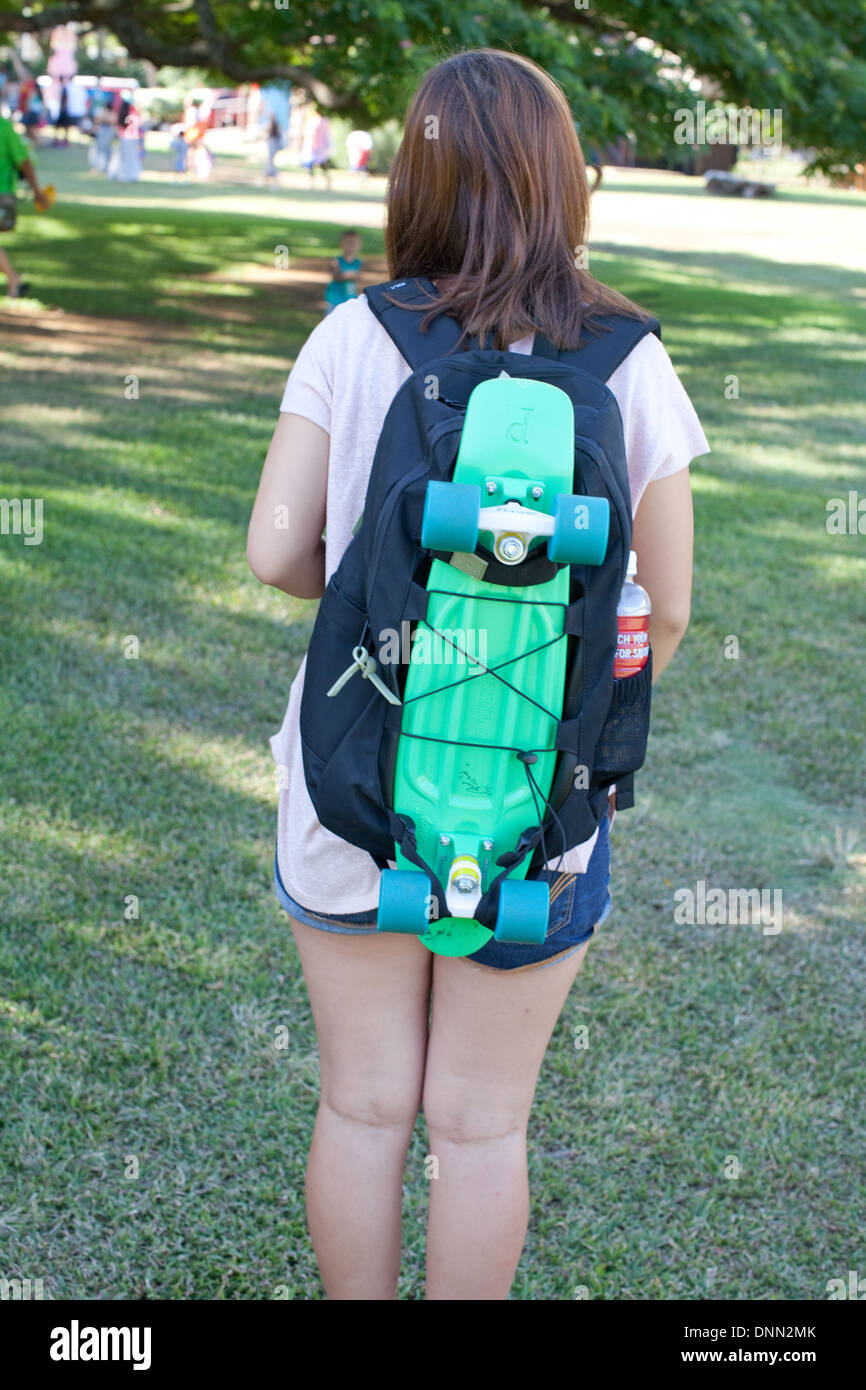 Teen indossando uno skateboard attaccato a zaino Foto Stock