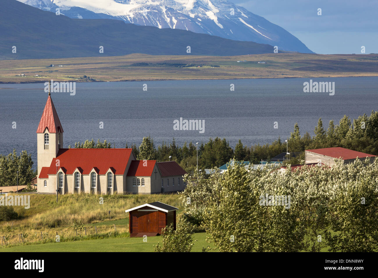 La Church Farm di Svalbar sul lato est del fiordo Eyjafj, nel nord-est dell'Islanda con vista di Snow capped mountain e il fiordo. Foto Stock