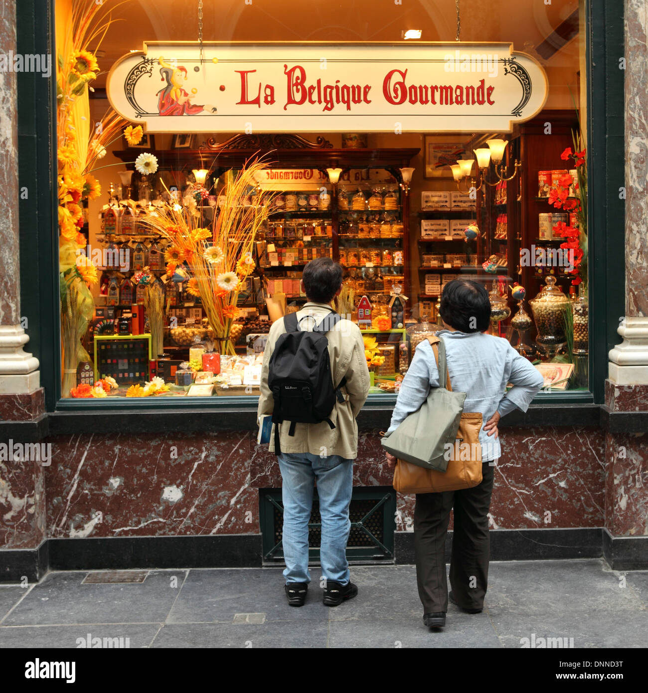 I turisti guarda un belga gourmet shop in Galeries Royales Saint-Hubert galleria per lo shopping a Bruxelles, in Belgio. Foto Stock