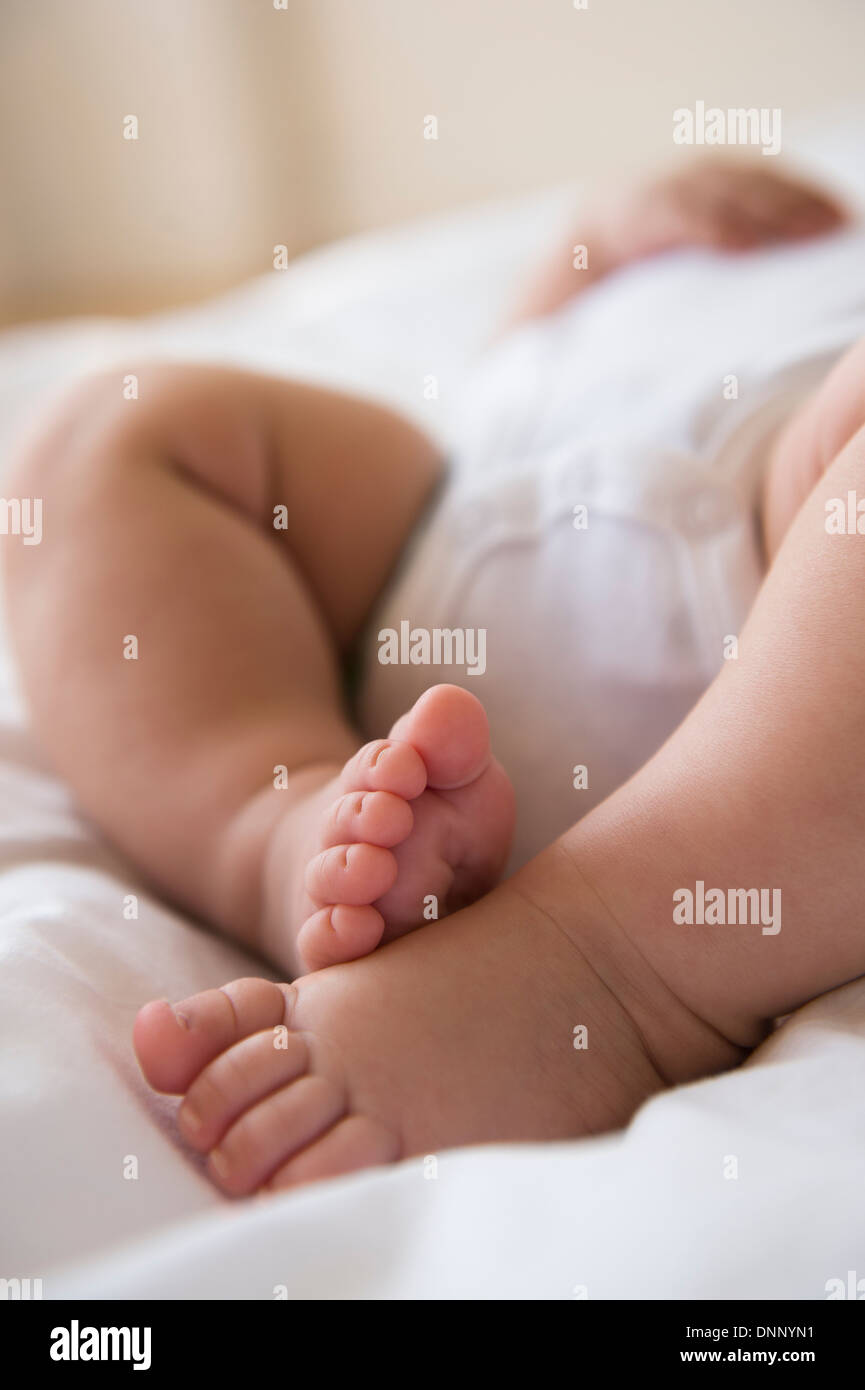 Piedi di bambina (2-5 mesi) giacenti nel letto Foto Stock