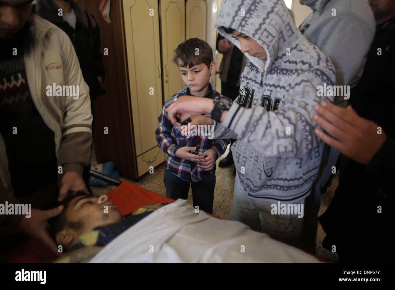 La striscia di Gaza, Territori palestinesi. 3 gennaio, 2014. Un ragazzo palestinese scatta una foto con il suo telefono al corpo del suo amico Adnan Abu Khater, 18, che è morto da ferite dopo i soldati israeliani sparato giovedì vicino la recinzione di confine nel nord della Striscia di Gaza. 3 gennaio 2014.Foto: Ahmed Deeb/NurPhoto Credito: Ahmed Deeb/NurPhoto/ZUMAPRESS.com/Alamy Live News Foto Stock