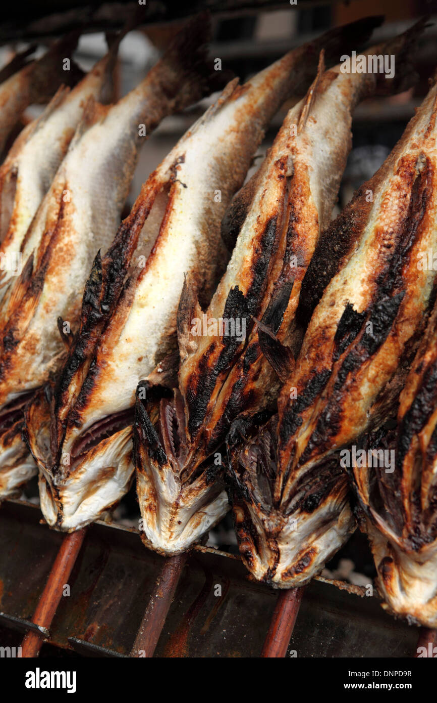 Steckerlfisch ("pesce su bastoni") cuocere su carbone al Oktoberfest a Monaco di Baviera, Germania. Foto Stock