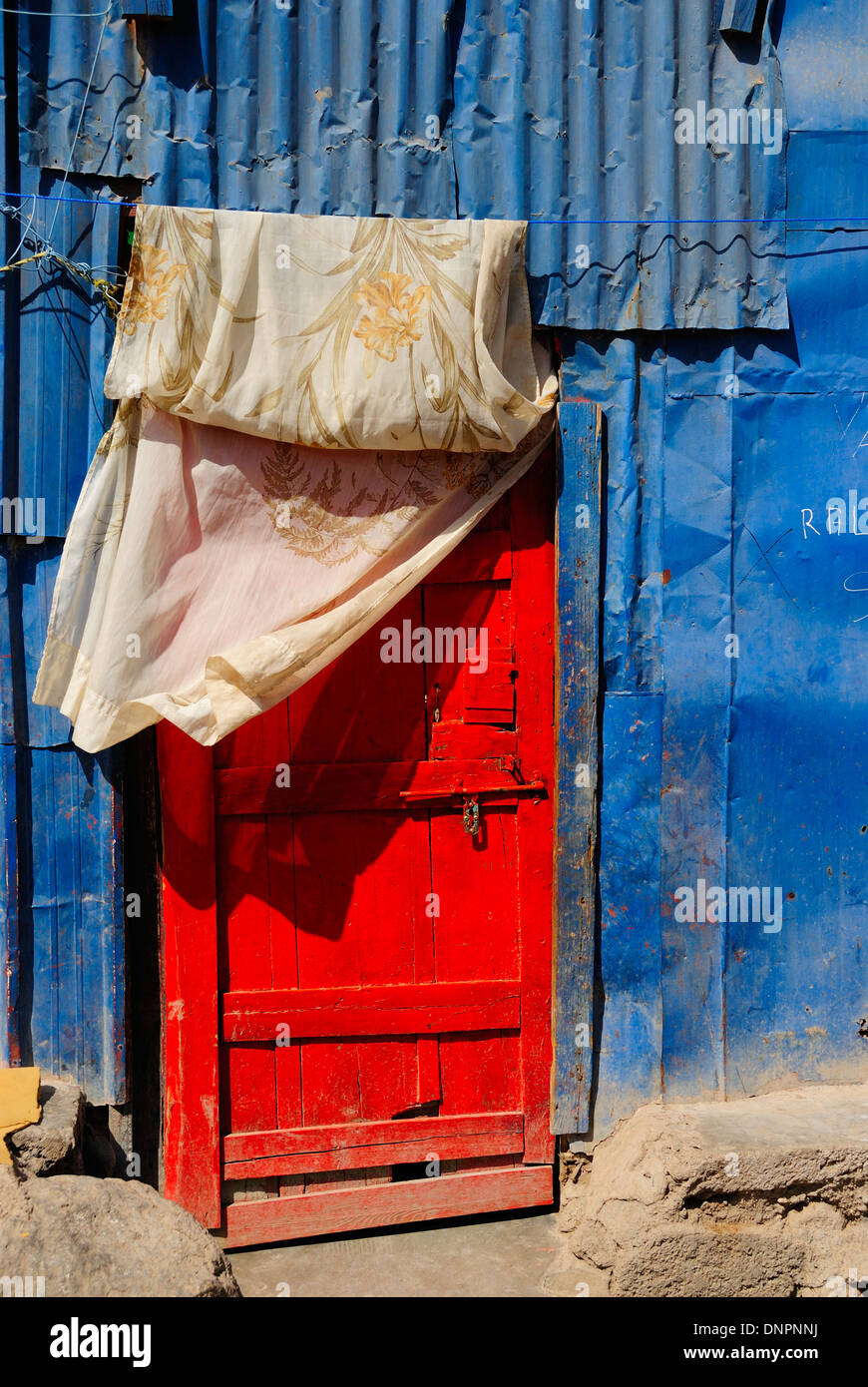 Porta Rossa di una casa costruita con lamiere di metallo lungo una strada di Balbala quartiere vicino a Gibuti, Gibuti, Corno d Africa Foto Stock