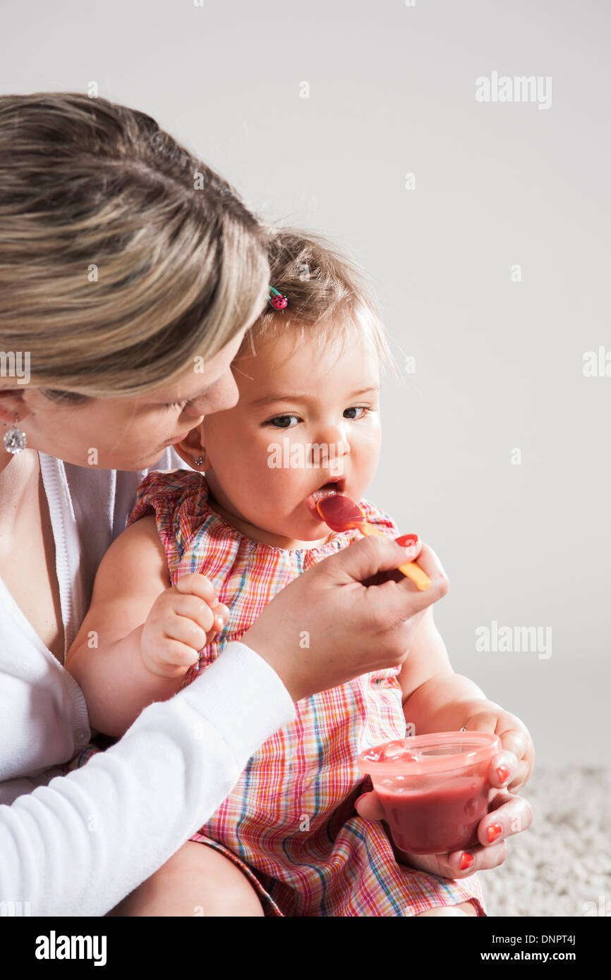 Ritratto di Madre Figlia di alimentazione, Studio Shot Foto Stock