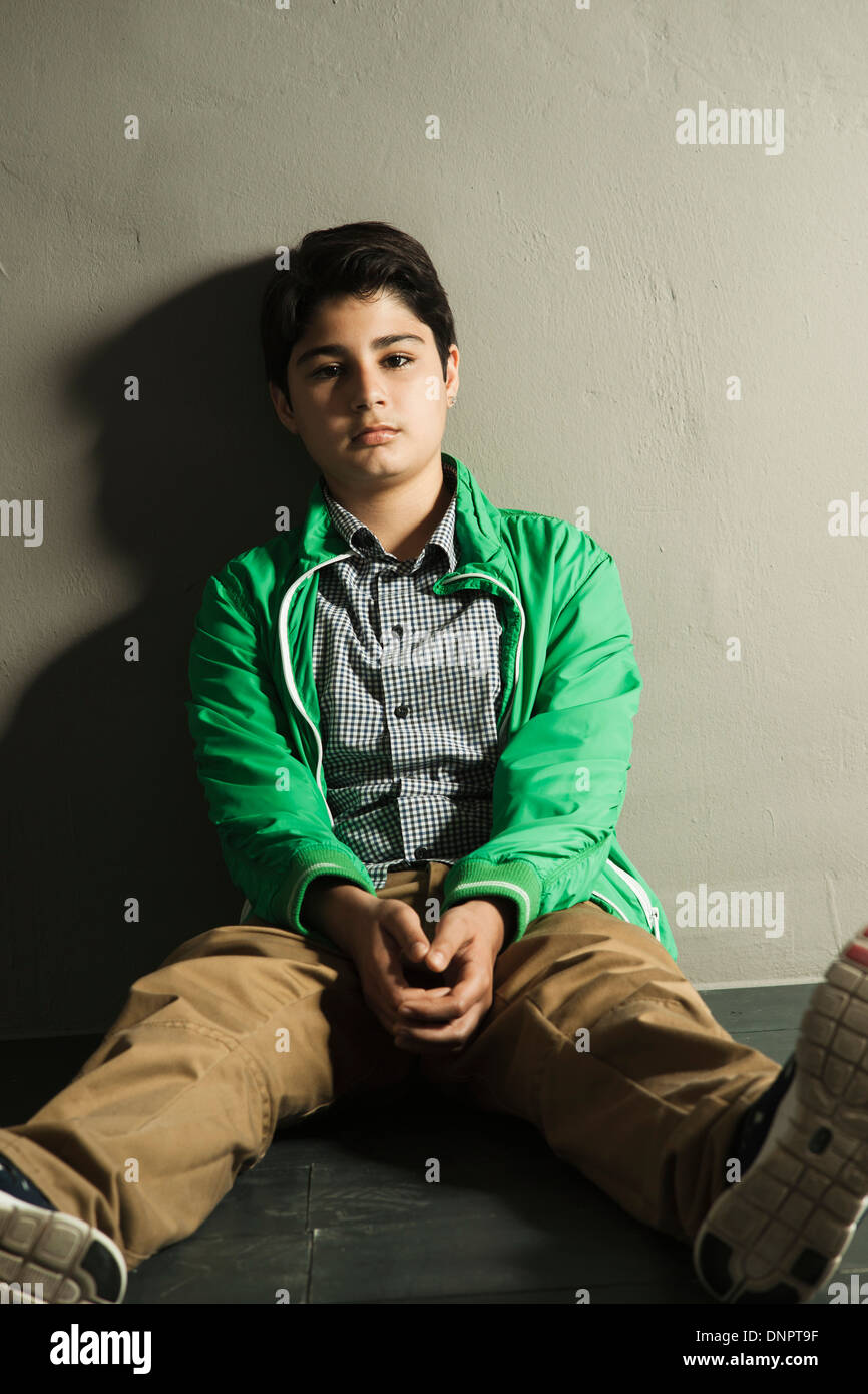 Ritratto di adolescente seduto sul pavimento, Studio Shot Foto Stock