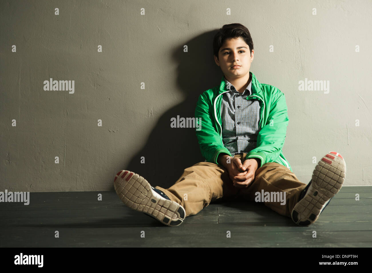 Ritratto di adolescente seduto sul pavimento, Studio Shot Foto Stock
