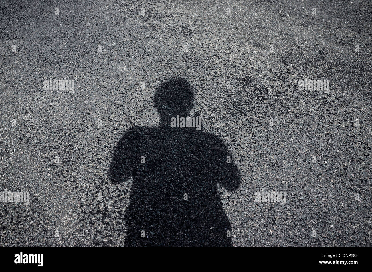 Ombra di uomo sulla strada asfaltata Foto Stock