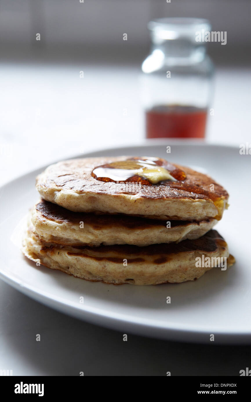 Close-up di pila di pancake con sciroppo d'acero sulla piastra Foto Stock
