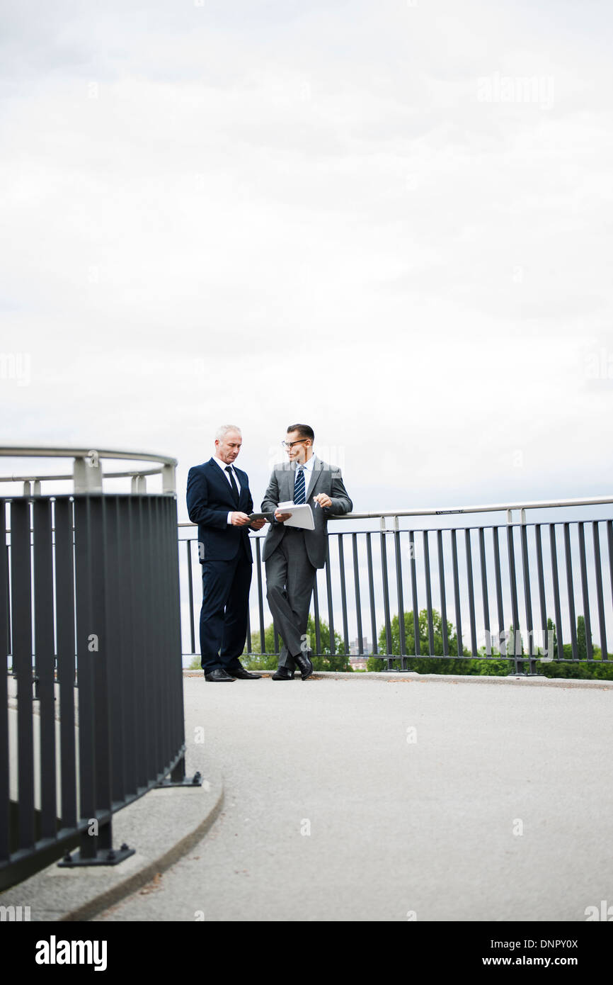 Imprenditori matura in piedi sul ponte, Mannheim, Germania Foto Stock