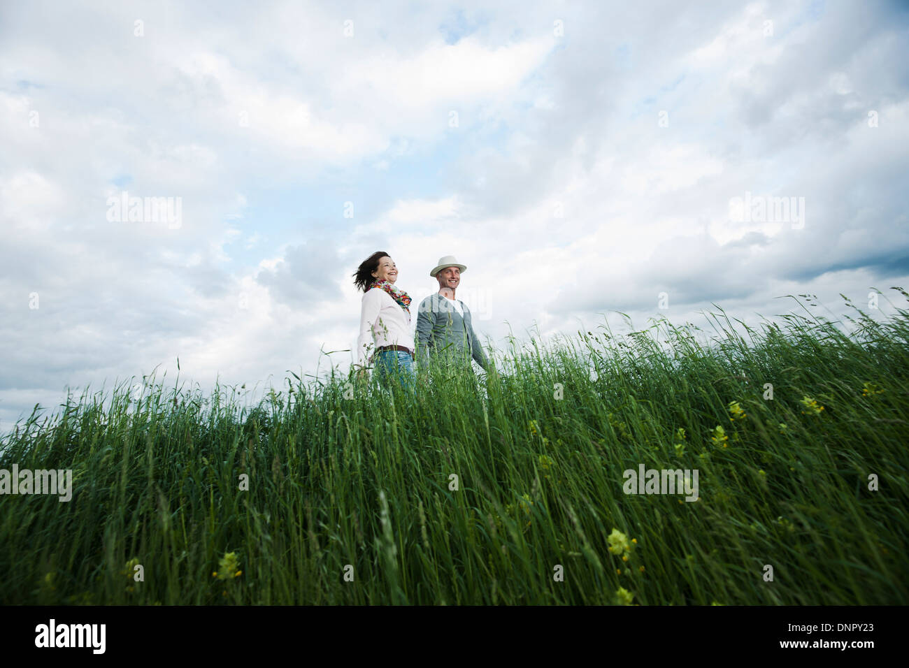 Coppia matura camminando nel campo di erba, Germania Foto Stock