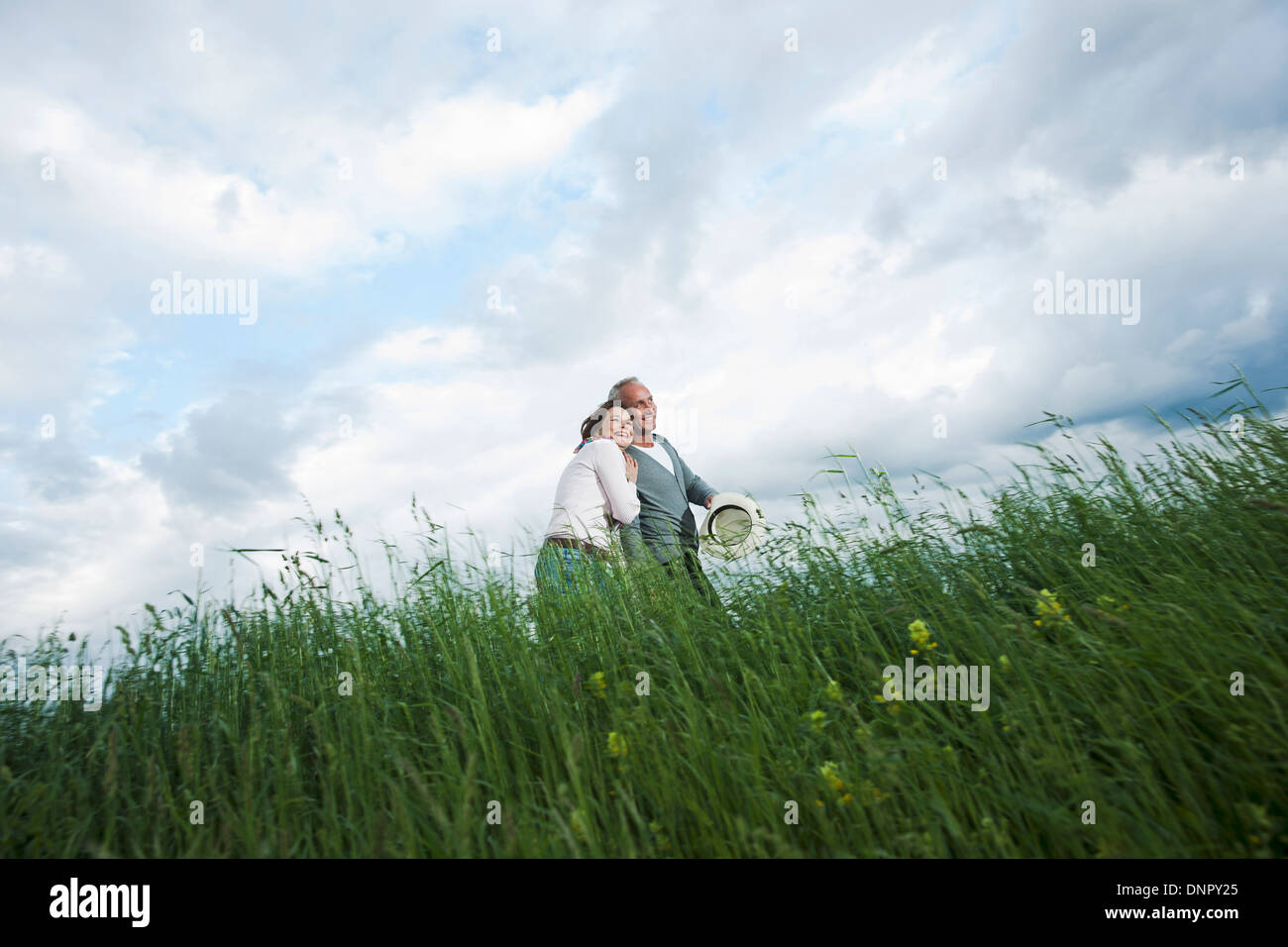 Coppia matura camminando nel campo di erba, Germania Foto Stock