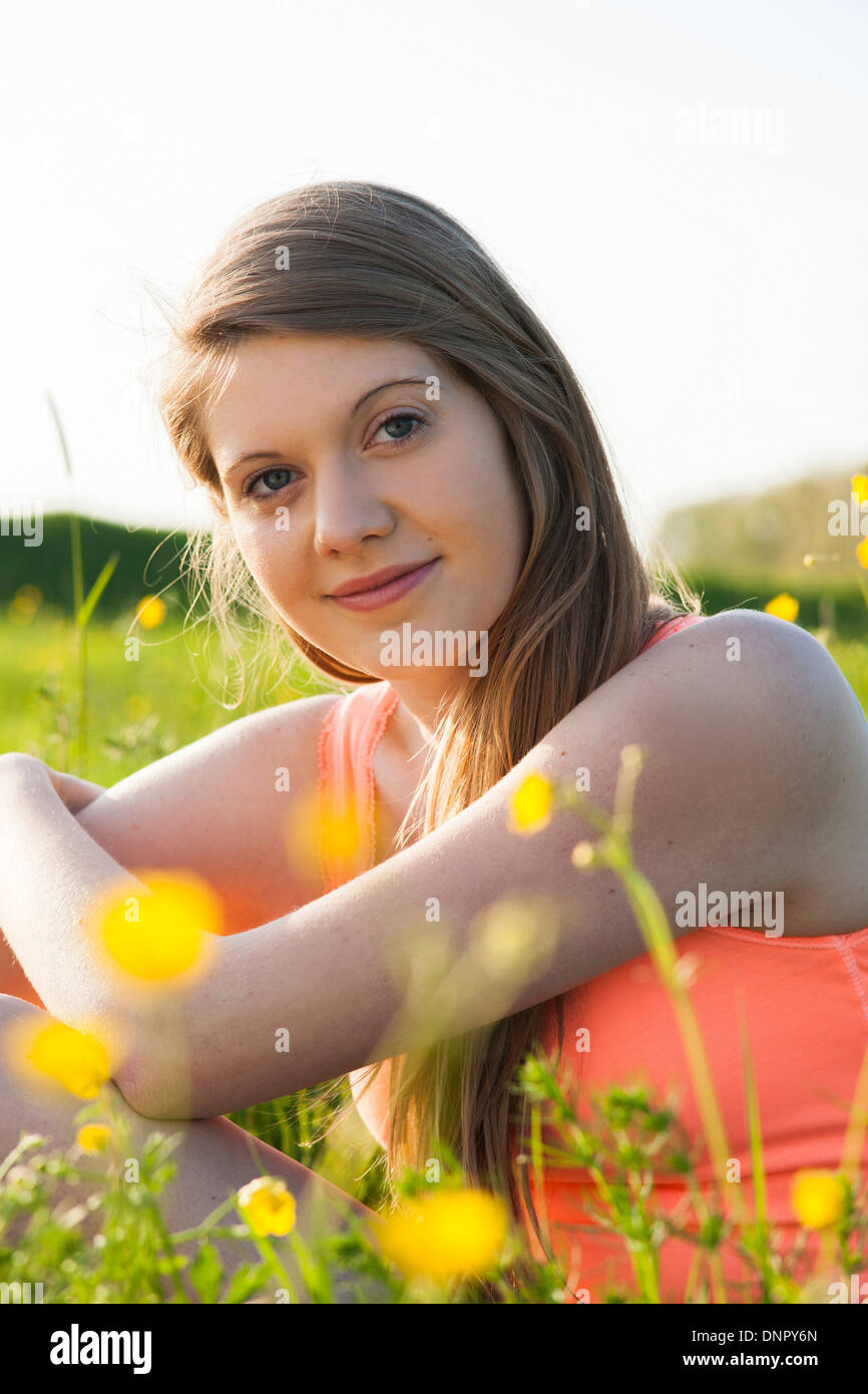 Ritratto di giovane donna seduta in campo, Germania Foto Stock