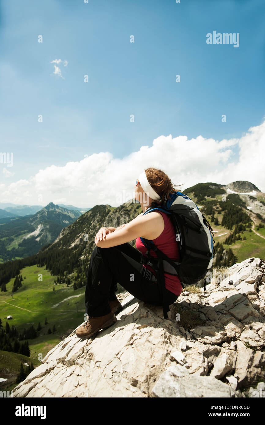 Coppia donna seduta sulla scogliera, escursioni in montagna, Valle di Tannheim, Austria Foto Stock