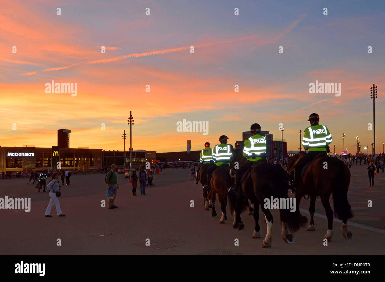 Ufficiali di polizia in serata pattugliamento a cavallo nel London 2012 Olympic Park abbigliamento ad alta visibilità che riflette luce alta Viz alto vis Inghilterra UK Foto Stock