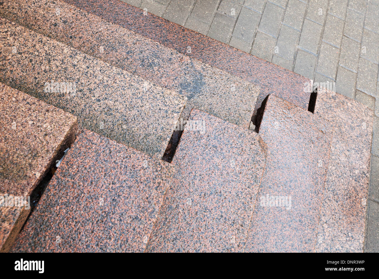Scale antiche fatte di granito rosso sul marciapiede grigio Foto Stock