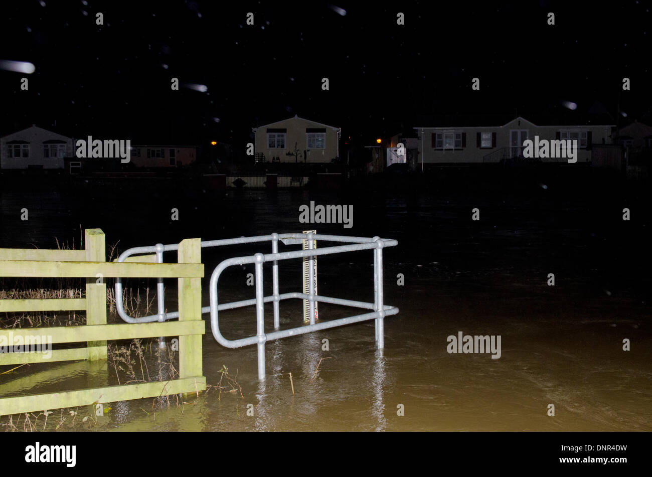 Iford, Christchurch, Dorset, Regno Unito . 02Jan, 2014. I residenti sono evacuati dal ponte Iford Home Park sito. I livelli di acqua sono in aumento con alte maree di 10:00 di domani mattina. Piove con heavy rain meteo durante la notte e l'agenzia per l'ambiente è di avvertimento più inondazioni. I residenti sono arrabbiati dopo supporto scarso e non dei sacchi di sabbia sul giorno di Natale alluvione. La strada le luci sono accese ma le case sono vuote e nelle tenebre. Credito: Roger Allen Fotografia/Alamy Live News Foto Stock