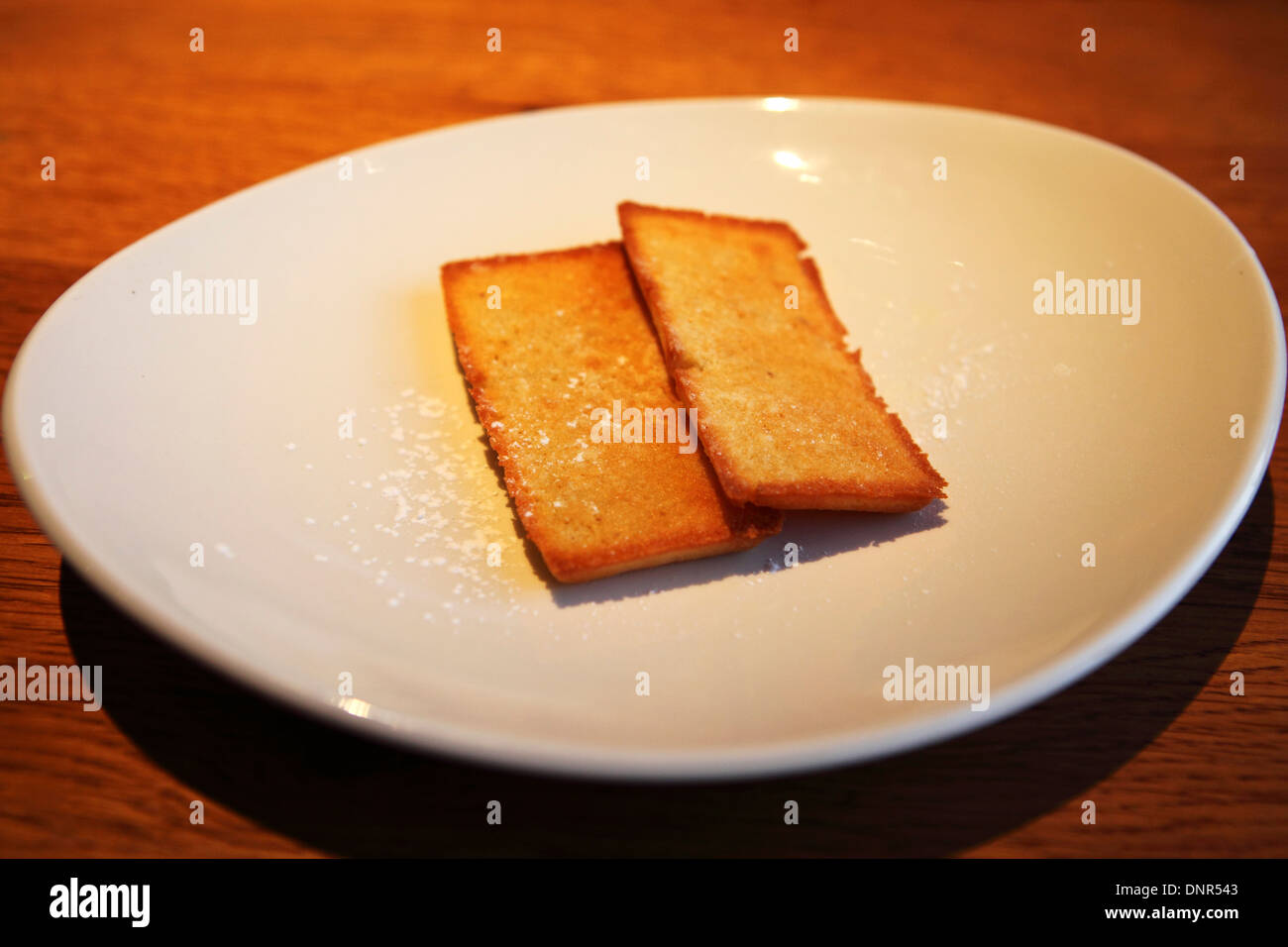 Madeleines piatto servito con una spolverata di zucchero a velo. Foto Stock