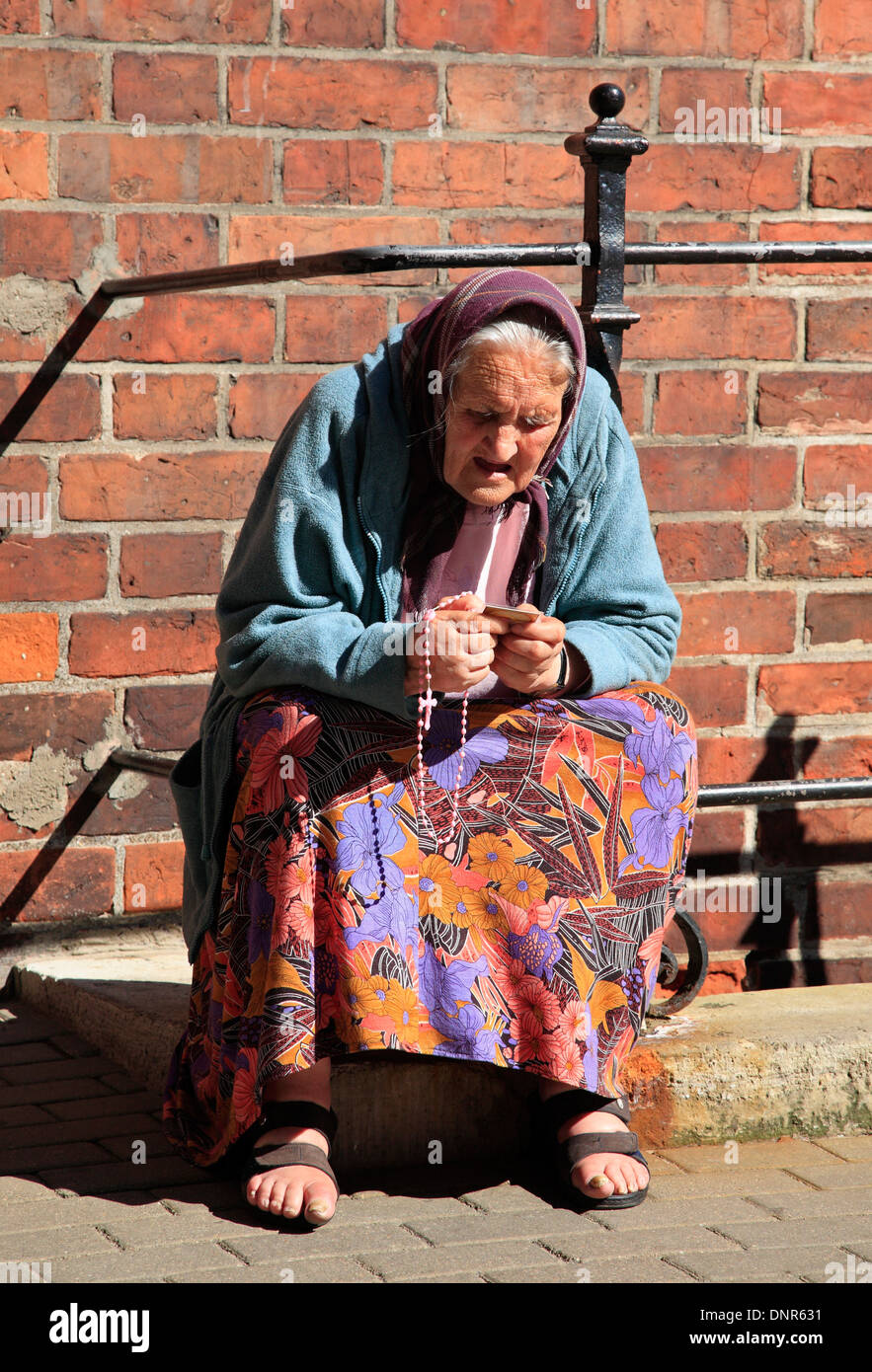 Donna anziana pregando presso la cattedrale, Riga, Lettonia, Europa Foto Stock