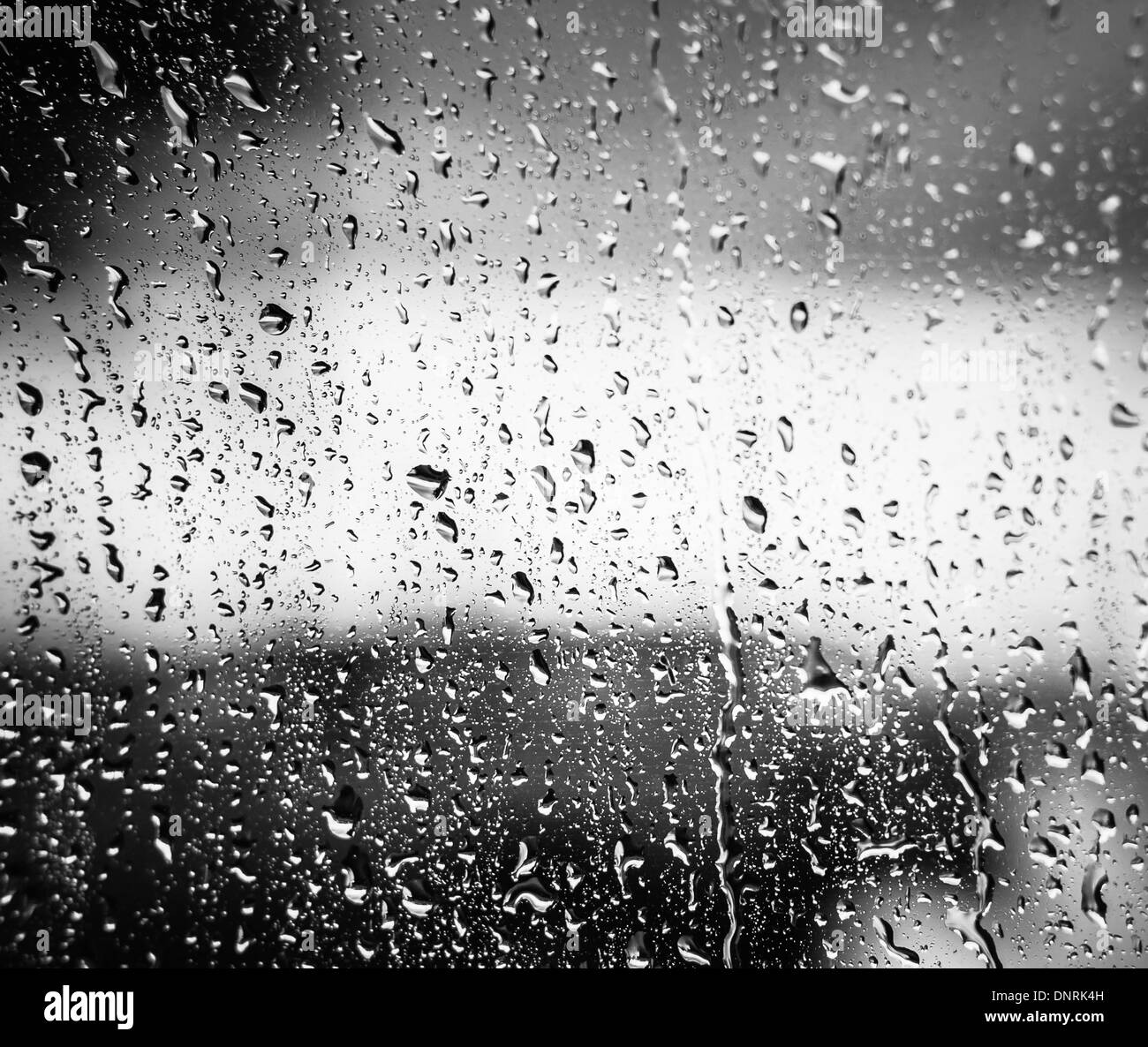 Acqua delle gocce di pioggia sul vetro su sullo sfondo di un cielo nuvoloso Foto Stock
