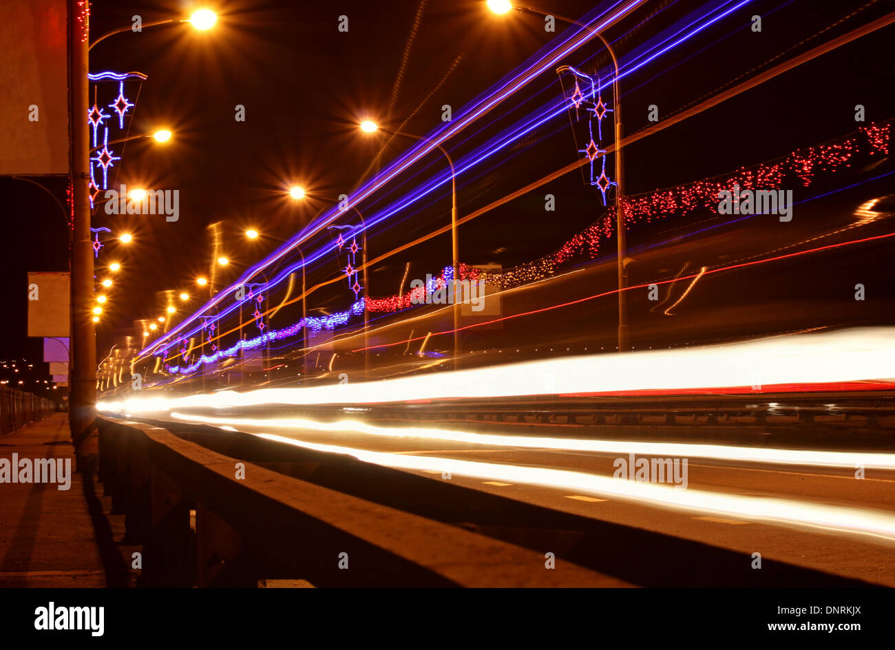 Tracce di luce di automobili sul ponte di notte Foto Stock