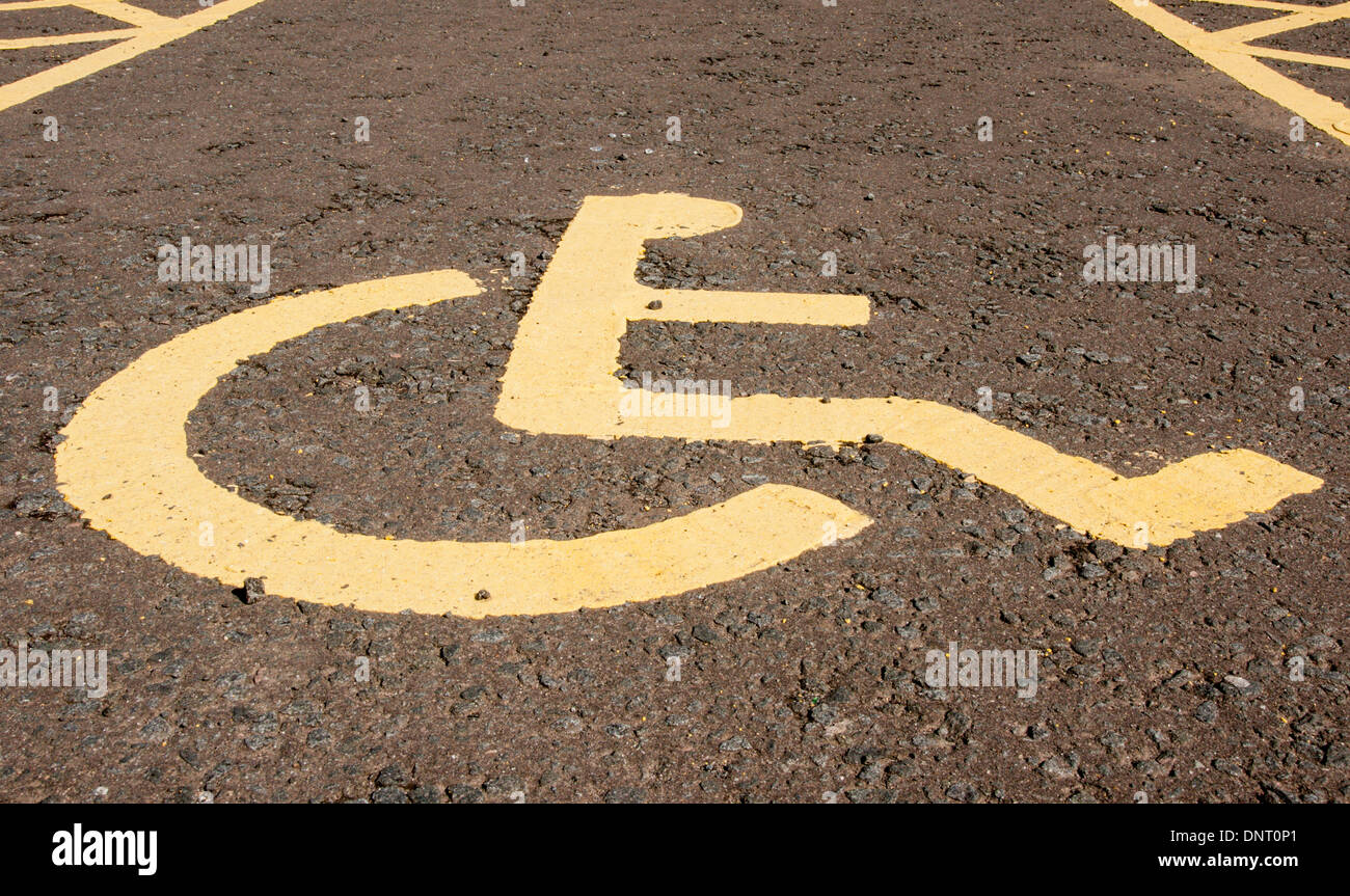 Il simbolo dipinto in un parcheggio riservato per le persone con una persona disabile di 'blue badge" permesso di parcheggio Foto Stock