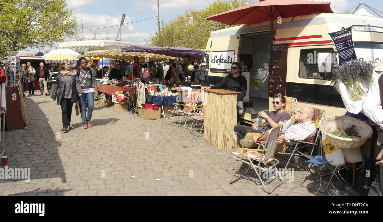 Sunny View, per la tettoia bancarelle del mercato, gente che passeggia, tre uomini al di fuori del caravan di vendere gelati, Mauerpark Mercato delle Pulci, Berlino Foto Stock
