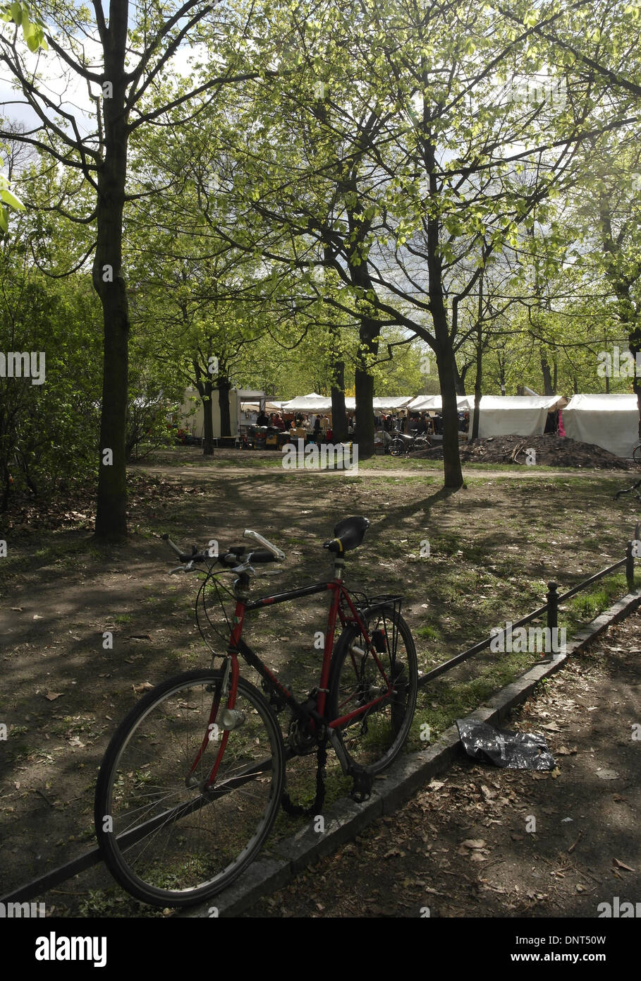 Noleggio incatenato al percorso-lato ringhiere metalliche, guardando attraverso gli alberi alti di tettoie bianco le bancarelle del mercato, Arkonaplatz, Berlino Foto Stock