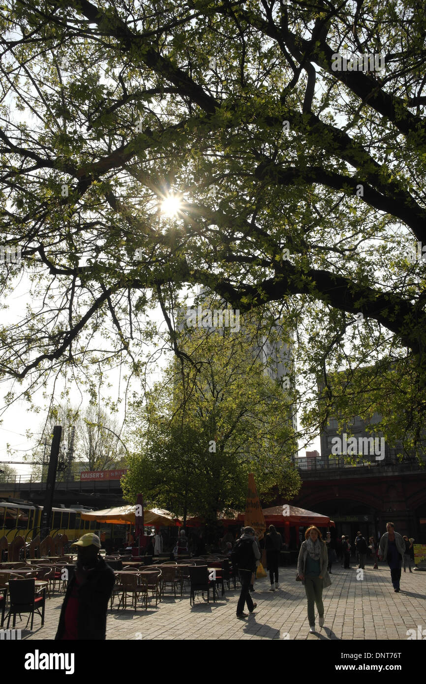 Sun stella che brilla attraverso i rami degli alberi, gente che passeggia, Hackescher Markt, al viadotto ferroviario, An der Spandauer Brucke, Berlino Foto Stock