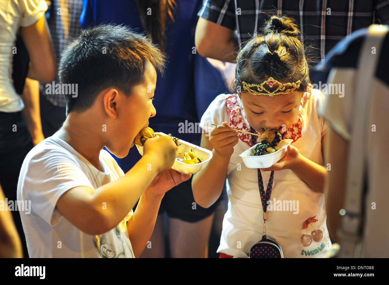 I ragazzi di mangiare cibo di strada, Hong Kong Foto Stock