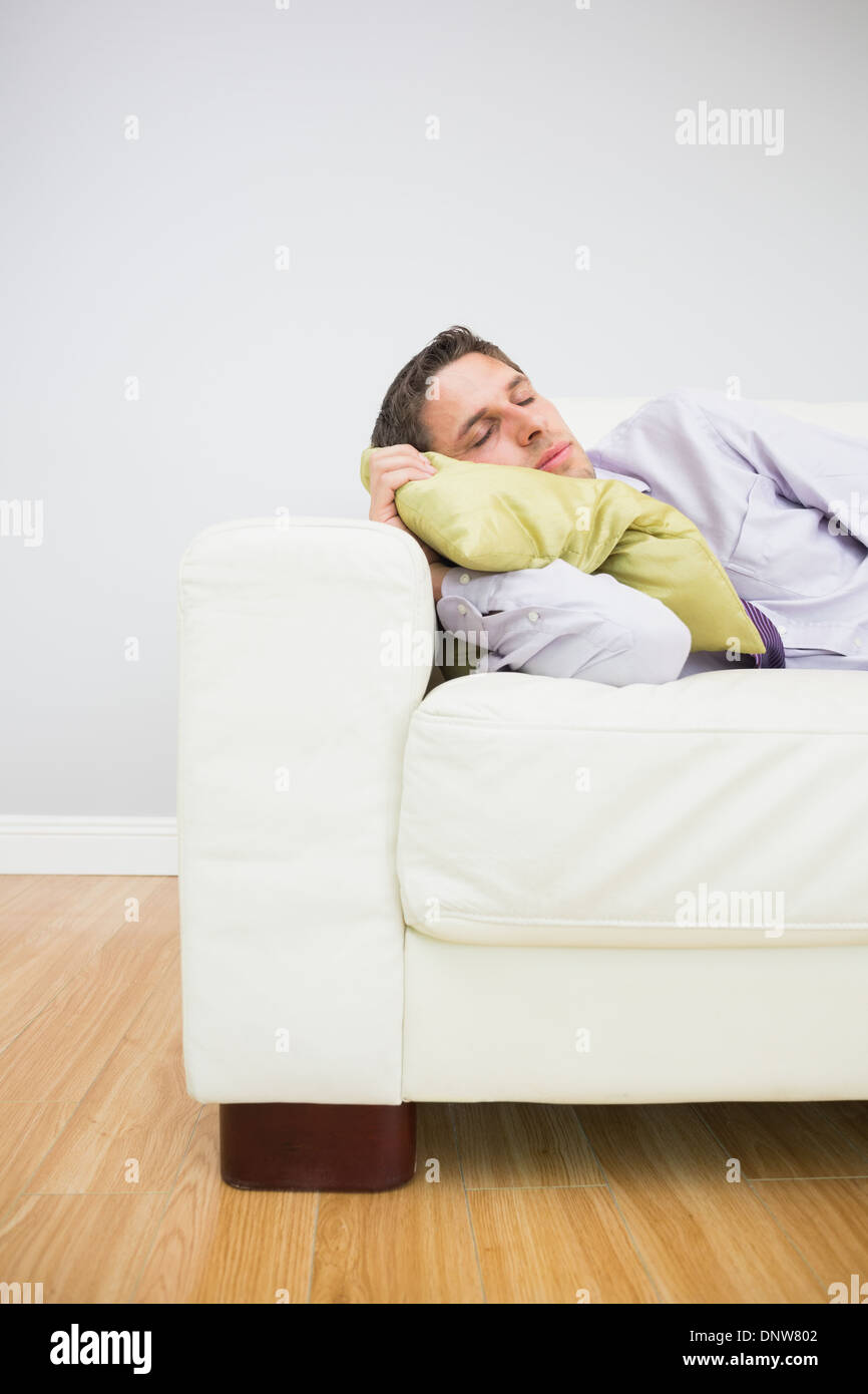 Imprenditore stanco di dormire sul divano nel soggiorno Foto Stock
