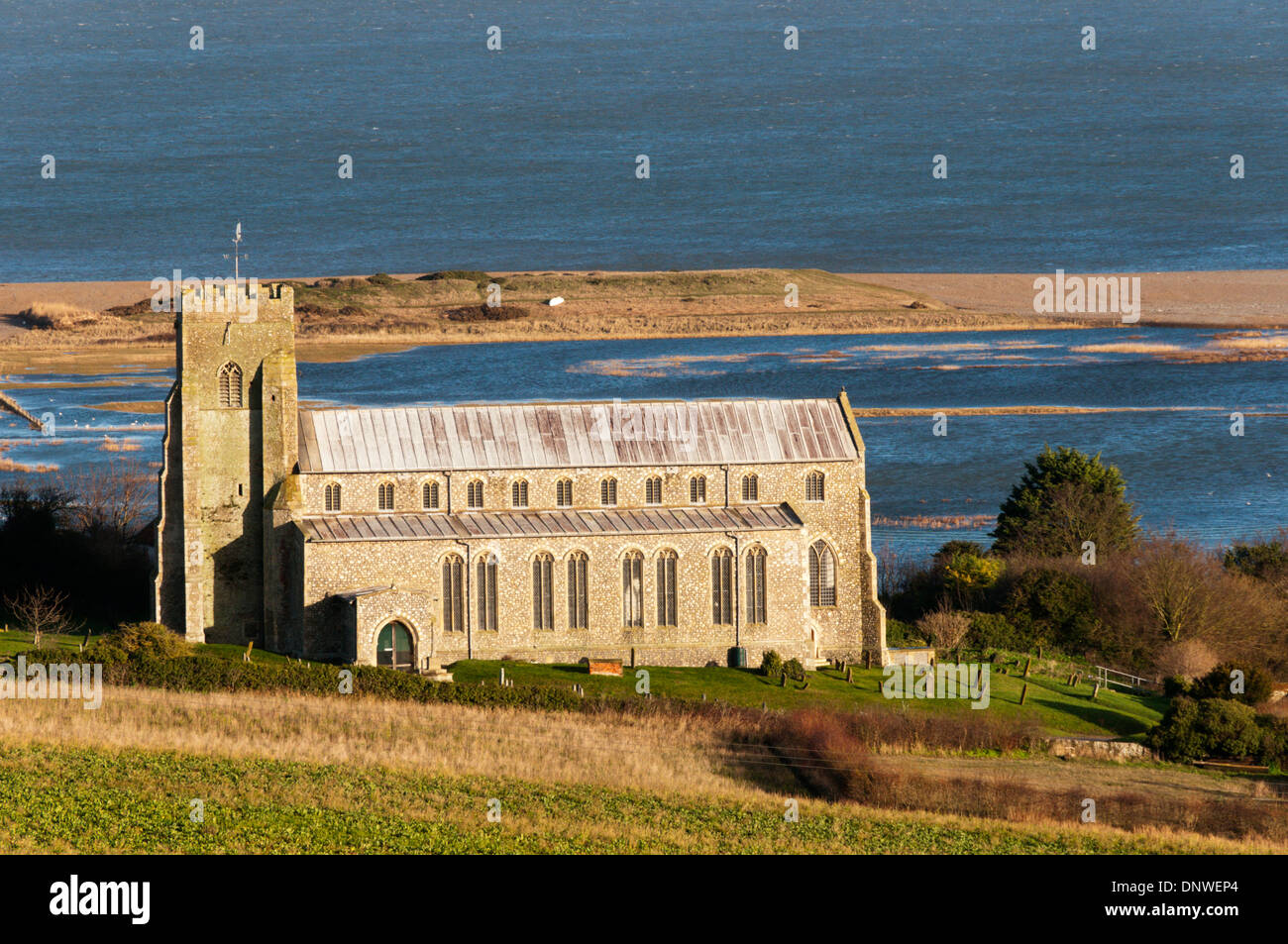 La chiesa di San Nicola a Salthouse vicino a Cley, di fronte allagato Salthouse Marsh saline sulla costa North Norfolk. Foto Stock