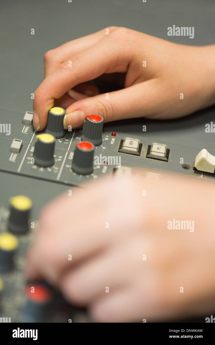 Mani lavorando su un suono miscelazione scrivania Foto Stock